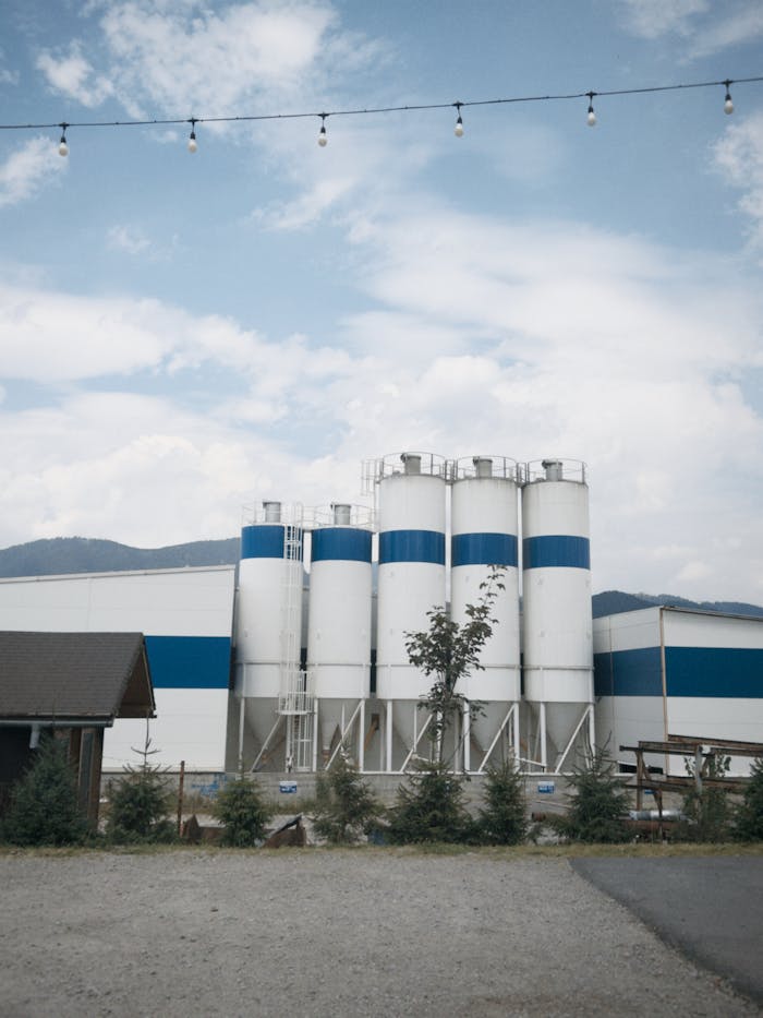 Modern industrial silos against a blue sky backdrop, showcasing advanced storage solutions.